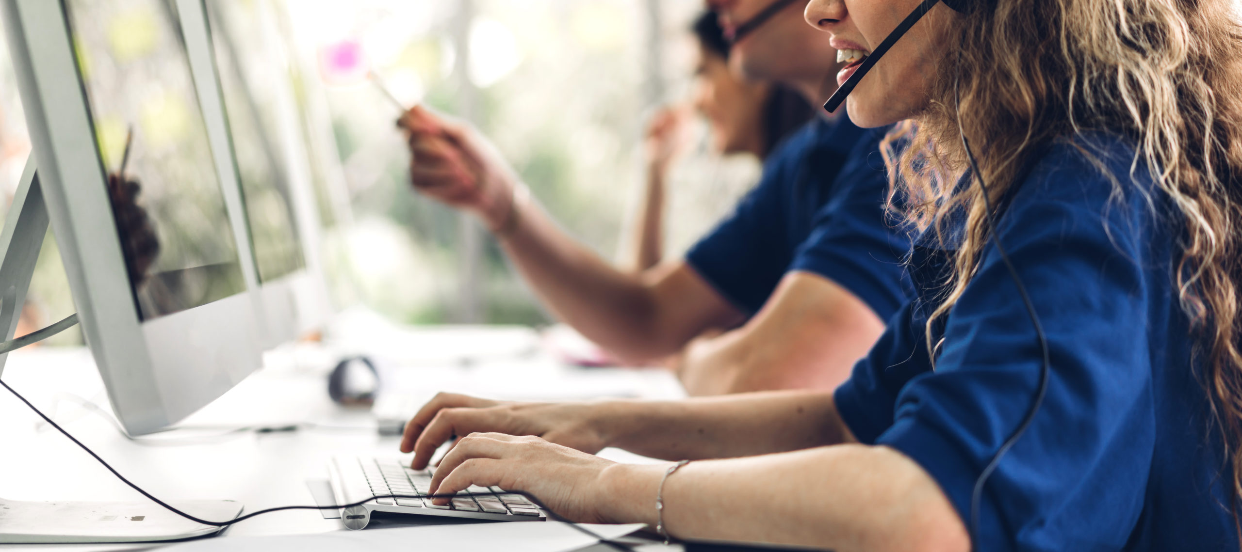 Group of happy smiling business operator customer support team phone services working with headset and computer at call center