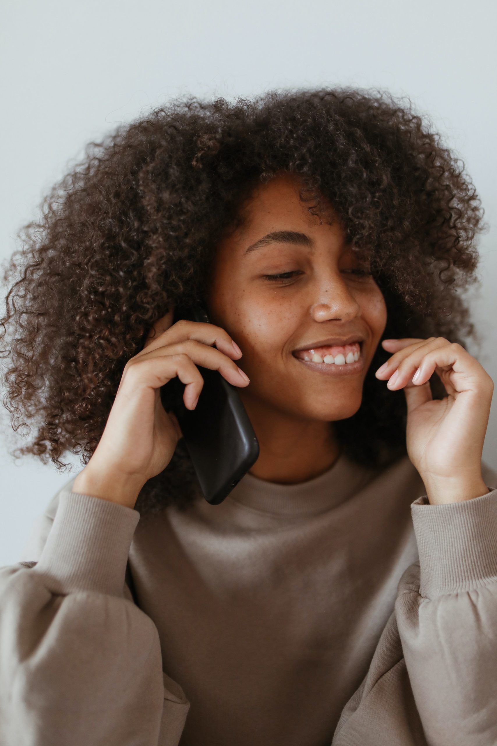 woman smiling while talking on the phone