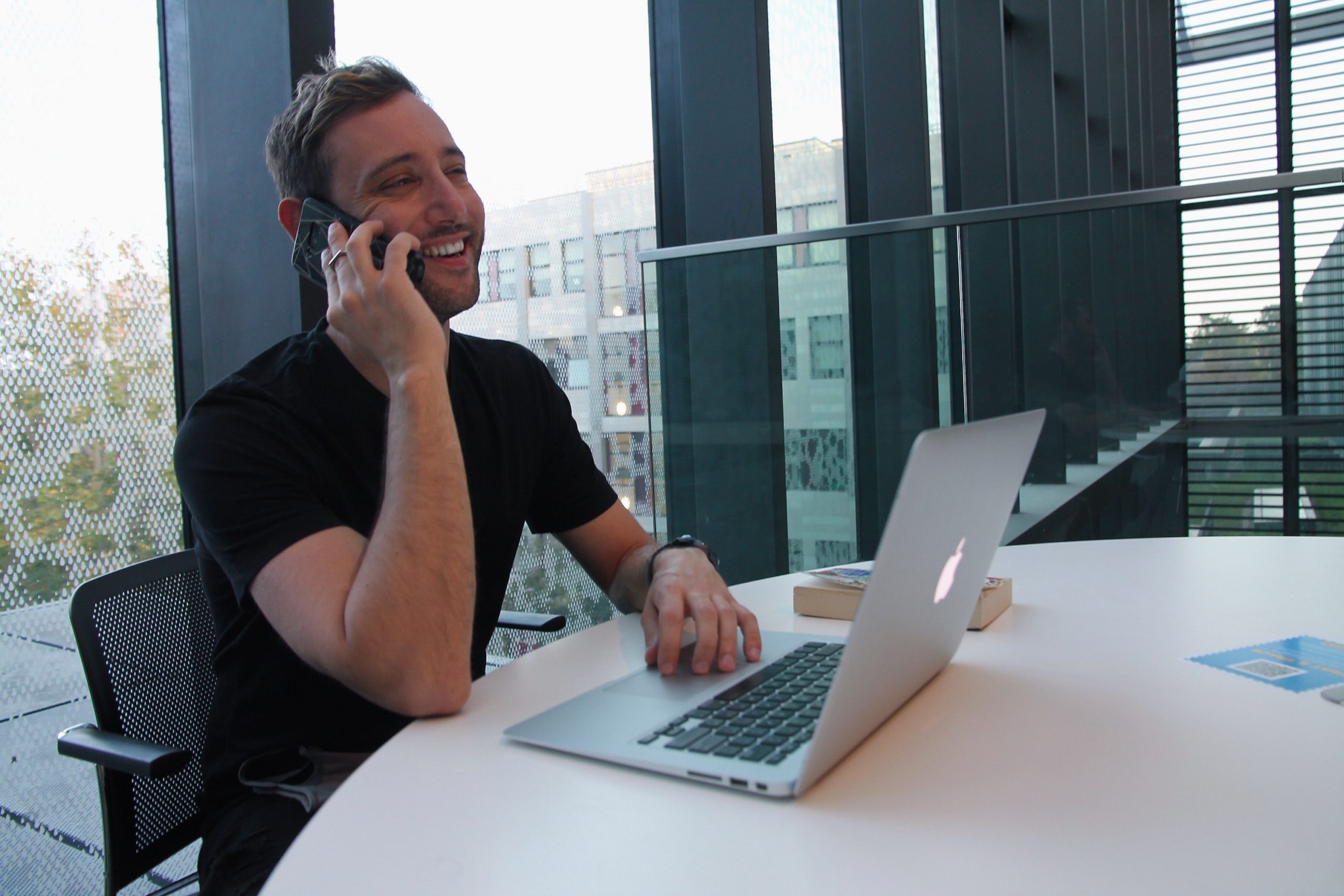 man in front of window talking on the phone