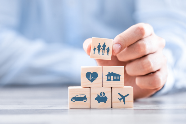 contactengine: photo of a person making a pyramid out of blocks representing various categories of insurance