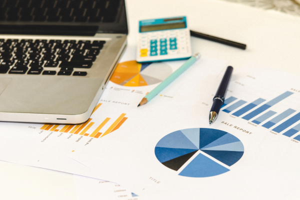 interaction data management: desk with pens, graphs and laptop