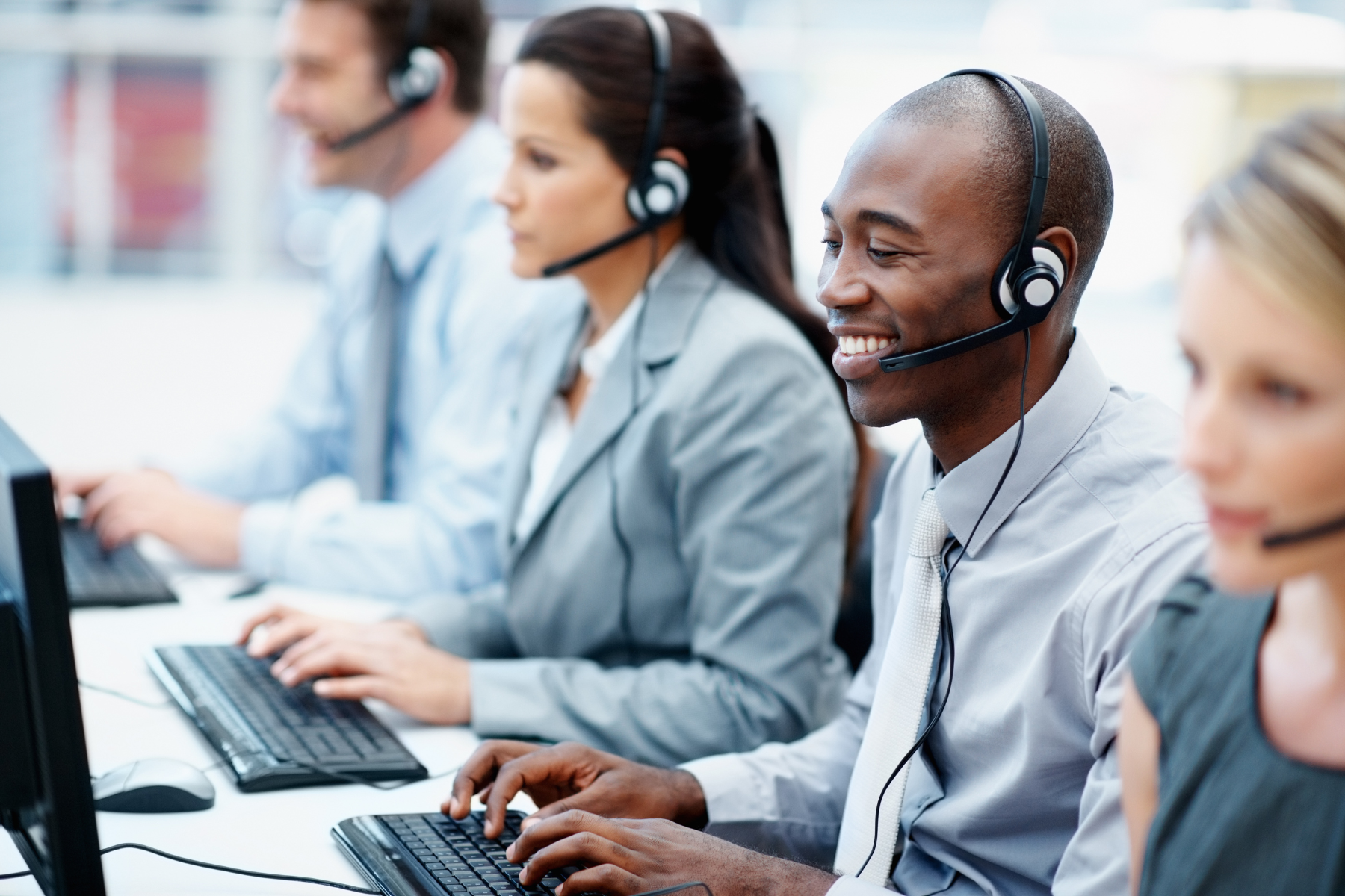 Digital CX Trends in contact centres in 2024: a row of contact centre agents sit at there desks.