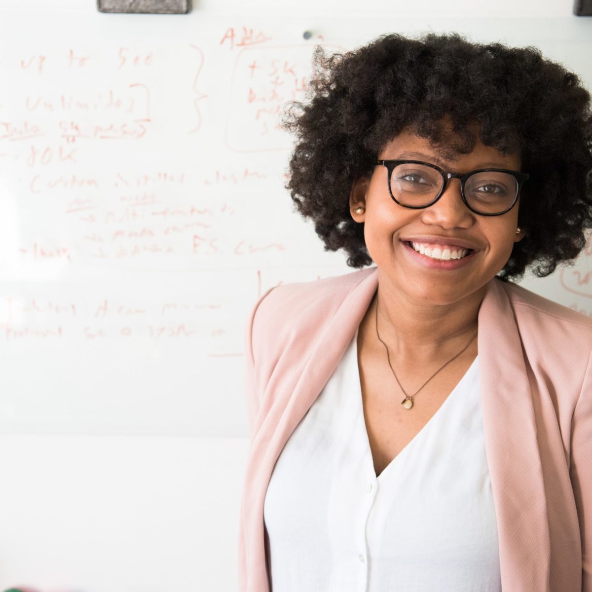 woman smiling in front of a whiteboard